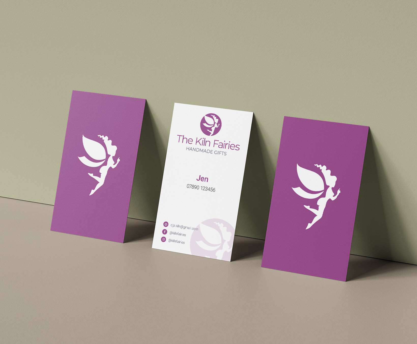 Brand Identity - Stationery - Mockup of three business cards standing up and leaning against a wall showing the front and back designs. 