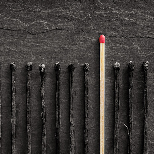 A single unused striking match in a line of burnt out matches to symbolise standing out from the crowd. 